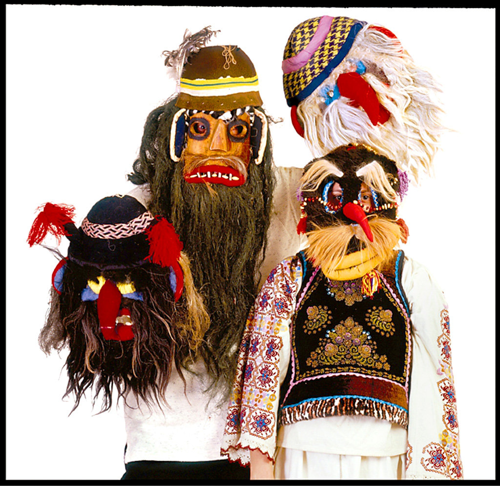 Photo of three figures in traditional Romanian masks