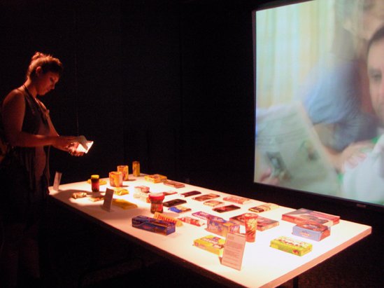 A women viewing a table covered with food items in a darkened room