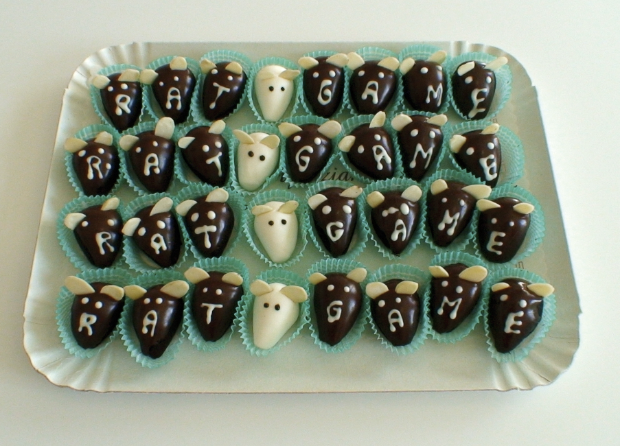 A tray of chocolates in the shape of rat heads. They spell out "Rat Game."